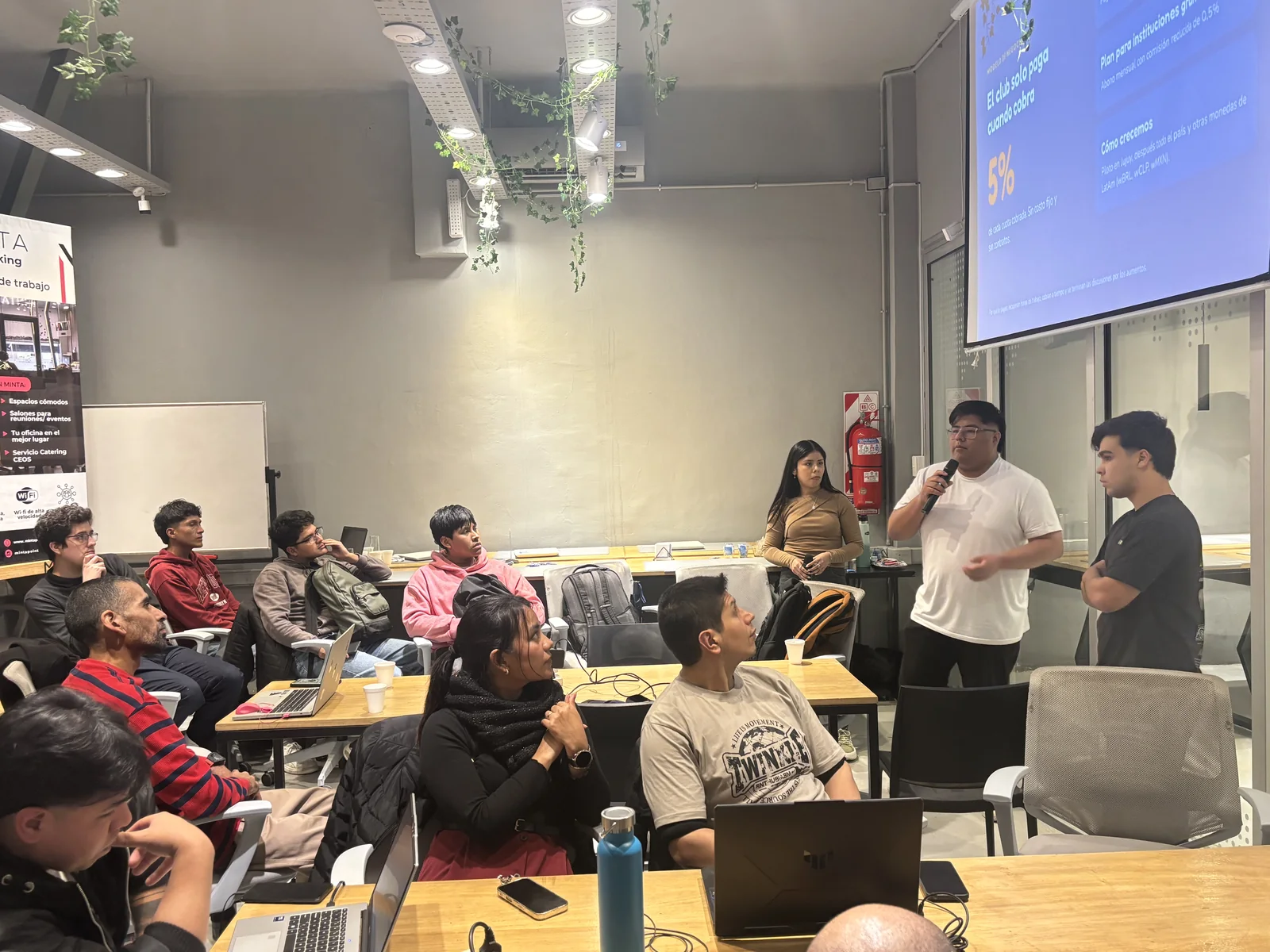 Presentación con micrófono en un meetup de la comunidad, con el público sentado